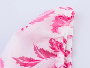 Détail du tissu en mousseline fleurie montrant les poignets élastiques et les motifs