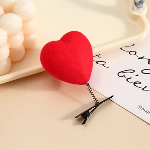 Cute red plush heart hair clip with spring fastener on a minimalist background