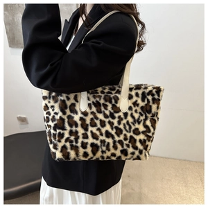 Close-up of leopard print plush tote bag with cream leather straps on model's shoulder