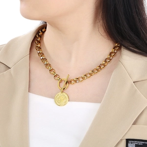 Détail d'un collier chaîne gourmette dorée avec médaille de Saint-Benoît et fermoir à bascule