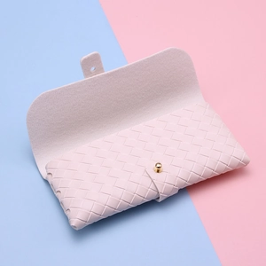 Detail of light pink woven leather sunglasses case with gold snap button and suede lining