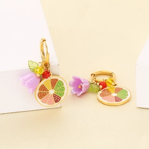 Detailed close-up of handmade lemon fruit earrings with colorful floral charms on a platform