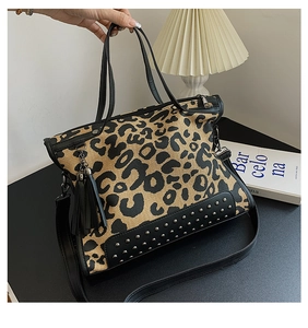 Detail of leopard print tote bag with silver studs on black leather base and fringe