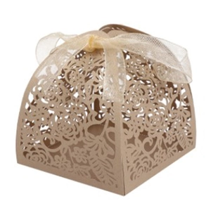 Close-up of beige laser-cut wedding favor box with an elegant ribbon bow detail