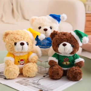 Three Christmas teddy bears in colorful festive hoodies and hats on an indoor background