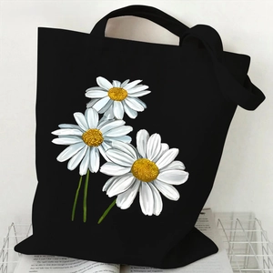 Minimalist black canvas tote bag featuring three white daisy flowers on a metal rack