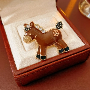 Macro detail of a vintage enamel horse brooch with crystals in a leather jewelry box