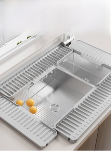 Modular grey silicone faucet splash guard with sloped drainage ridges for kitchen sinks
