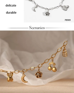Detailed close-up of stainless steel bracelet with moon, rose and cherry charms