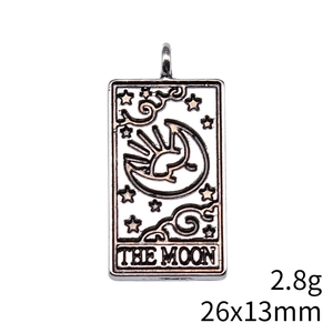 Macro detail of antique silver tarot card pendant with moon and star carvings