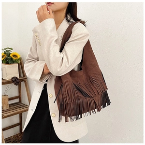 Brown frosted suede tote bag with fringe detail worn by model in a minimalist setting