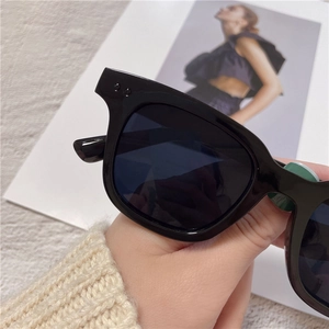 Close-up of classic black square sunglasses featuring a thick frame and polished finish