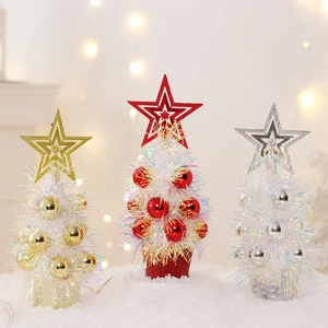 Detailed view of mini Christmas trees in gold, red, and silver on white snowy surface