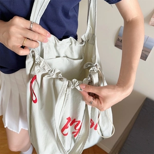 Detail view of the interior compartment and inner pocket of the gray nylon drawstring bag