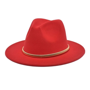 Macro detail of red wool fedora hat featuring a stylish thin gold metallic band decoration