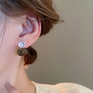 Macro shot of dopamine style double-bead earrings in translucent smokey grey finish