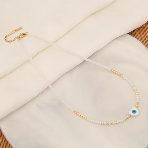 Bohemian evil eye heart necklace with white crystal beads on marble display