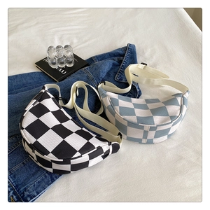 Detailed view of checkered crescent crossbody bags in black and light blue fabric
