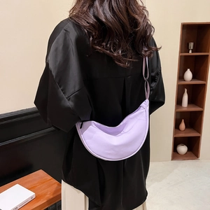Minimalist purple nylon half-moon crossbody bag with adjustable wide strap on model