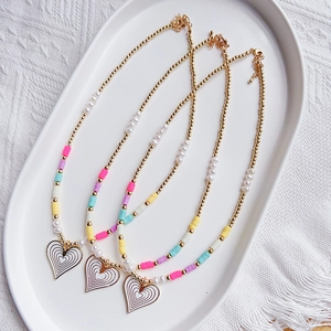 Close-up of Bohemian beaded necklace set with heart pendant in a ceramic tray