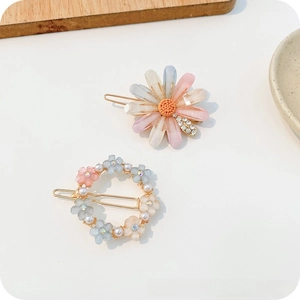 Detailed shot of resin daisy and floral hair clips with pearls and rhinestones