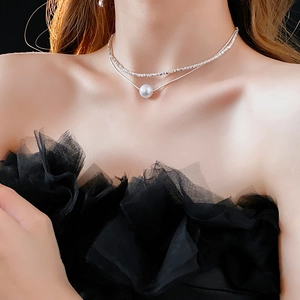 Détail d'un collier double épaisseur avec perles d'argent et pendentif perle blanche