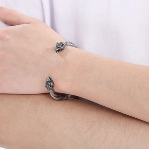 Gros plan d'un bracelet jonc tête de loup vintage avec texture torsadée sur le poignet