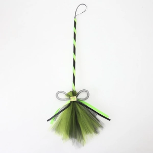 Detail of neon green and black striped witch broom with a sparkling silver sequin bow