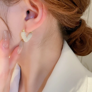 Close-up of elegant V-shaped heart pearl earrings with gold-toned finish for women