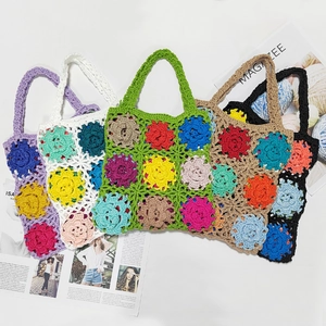 Detailed close-up of multi-colored handmade crochet flower tote bags with floral patterns