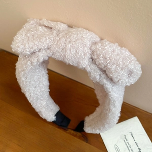 Close-up of pink faux shearling headband showing the soft lamb wool texture and thick padding