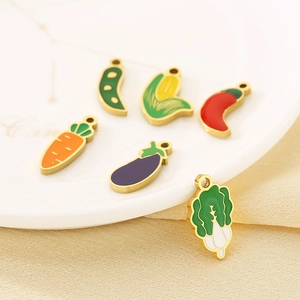 Detail of colorful enamel vegetable charms in carrot, corn, and eggplant for DIY jewelry