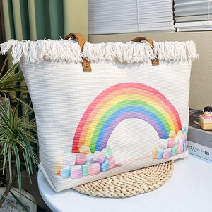 Detailed shot of rainbow pattern and soft cotton cloud charms on woven canvas bag