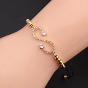 Macro detail of adjustable infinity bracelet with zircons and gold beads on wrist