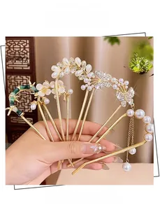 Détail du lot de cinq épingles à cheveux en U avec papillons dorés, perles et glands fins