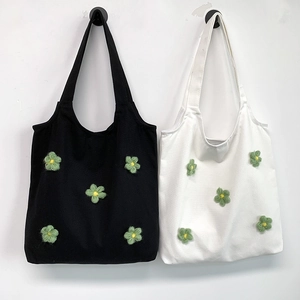 Floral canvas tote bags in black and white with 3D knitted green flower decorations