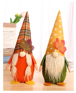 Detail of harvest gnomes with maple leaf motifs and knitted hats on a wooden surface