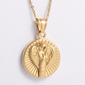 Macro detail of golden cobra pendant showing embossed snake texture and radiating lines