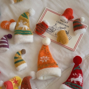 Detailed macro view of assorted mini knitted Christmas hats and gloves for DIY crafts