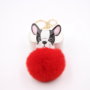 Detail of red plush faux fur pompom with French Bulldog leather charm and gold hardware