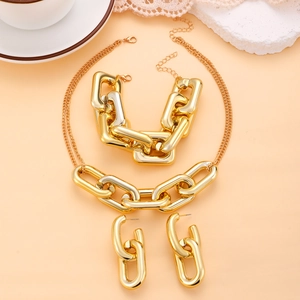 Golden chunky chain jewelry set including a necklace, bracelet and earrings on a pink base