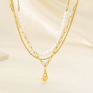 Macro shot of gold-plated triple-layer necklace featuring heart lock pendant and pearls