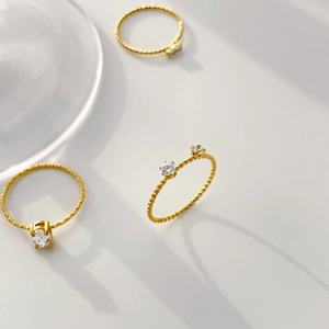 Detailed view of 18K gold plated twisted band rings with zircon stone settings