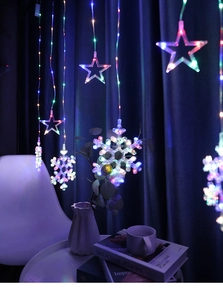 Detail of colorful LED curtain lights with star and snowflake shapes for room decor