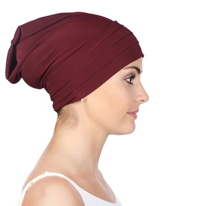 Detail showing the burgundy pleated fabric texture on a stylish women's head wrap