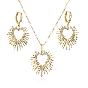 Golden heart jewelry set with pink stones and spiked halo on white background