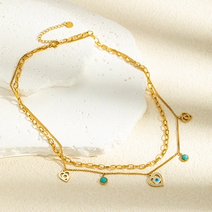 Détail du collier doré multi-rangs avec perles turquoise et pendentif oeil protecteur