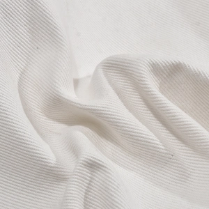 Détail macro du tissu en sergé de coton blanc montrant la texture de tissage de qualité