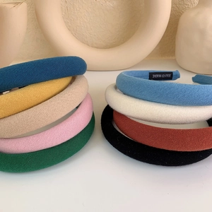Close-up of stacked colorful padded sponge headbands with handmade fabric label detail