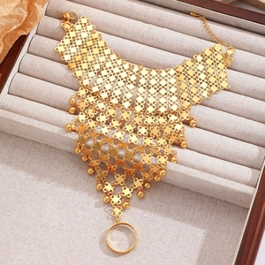 Nahaufnahme der goldenen Handkette mit Netzstruktur und Perlen im Ethno-Stil
